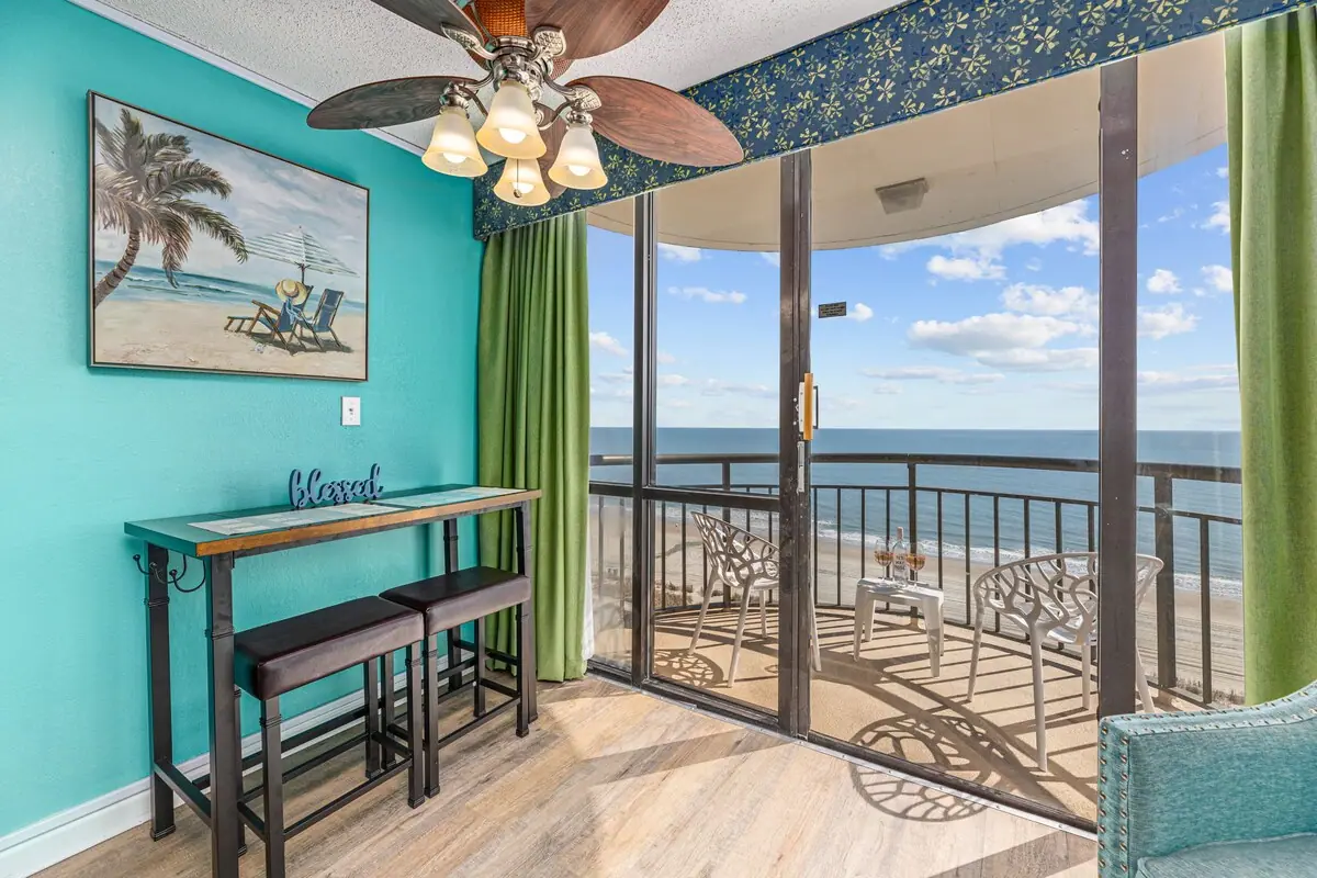 Dining nook beside glass balcony doors with the ocean beyond