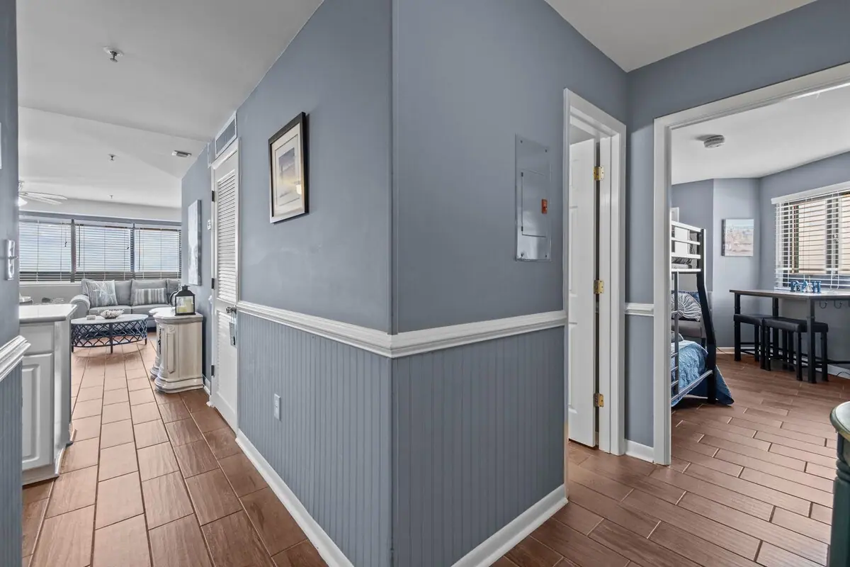 Gray paneled hallway opening toward the living room and dining area
