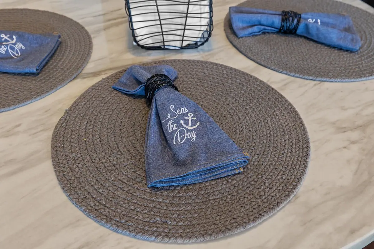 Folded blue napkins arranged on round dining place mats