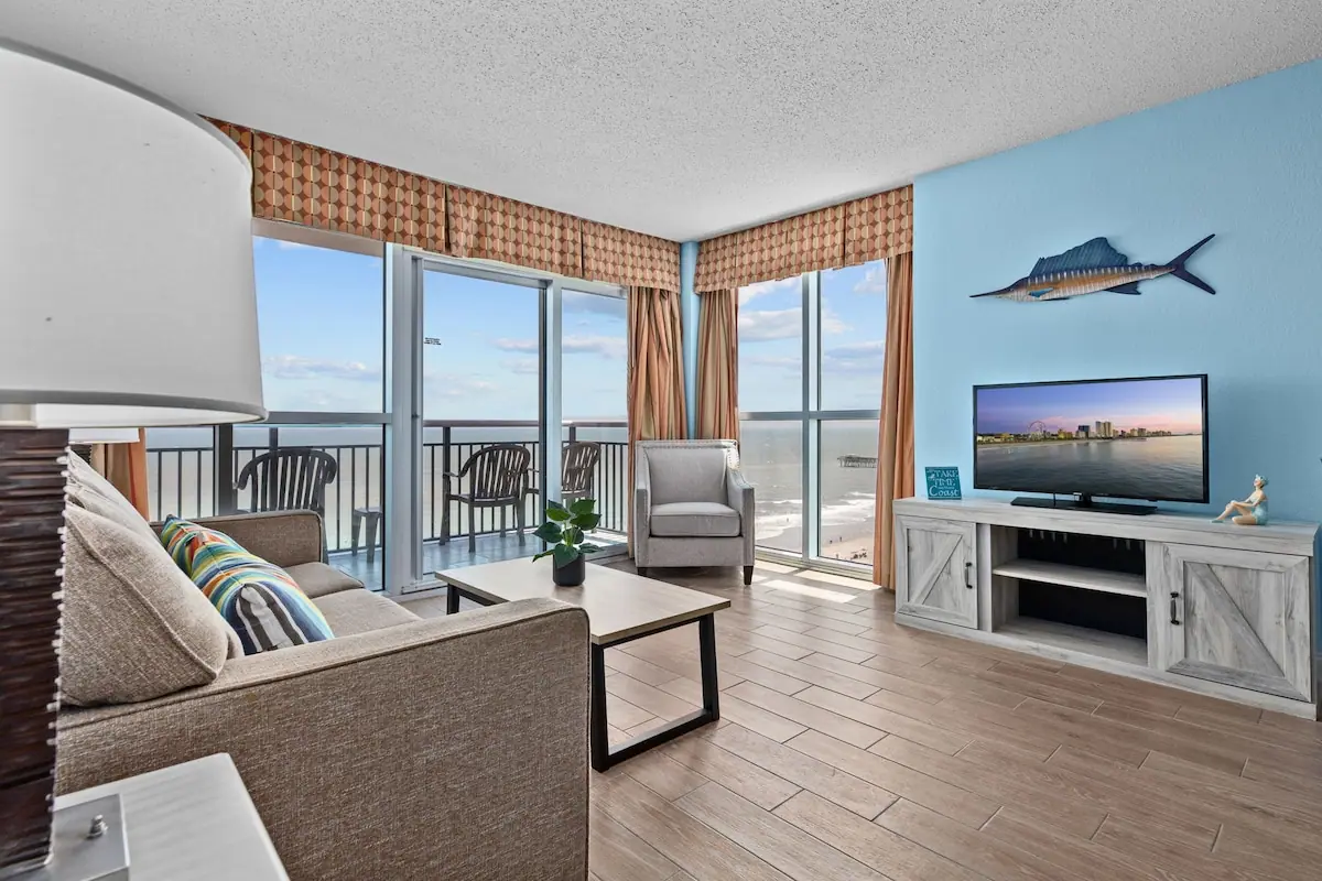 Living room with a sofa and corner windows opening onto a balcony