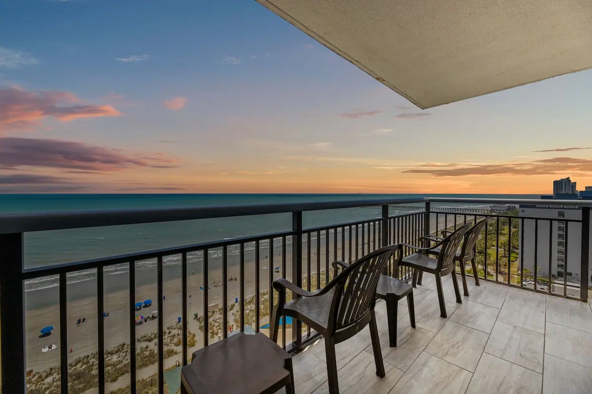 Balcony chairs overlooking the beach and ocean at sunset