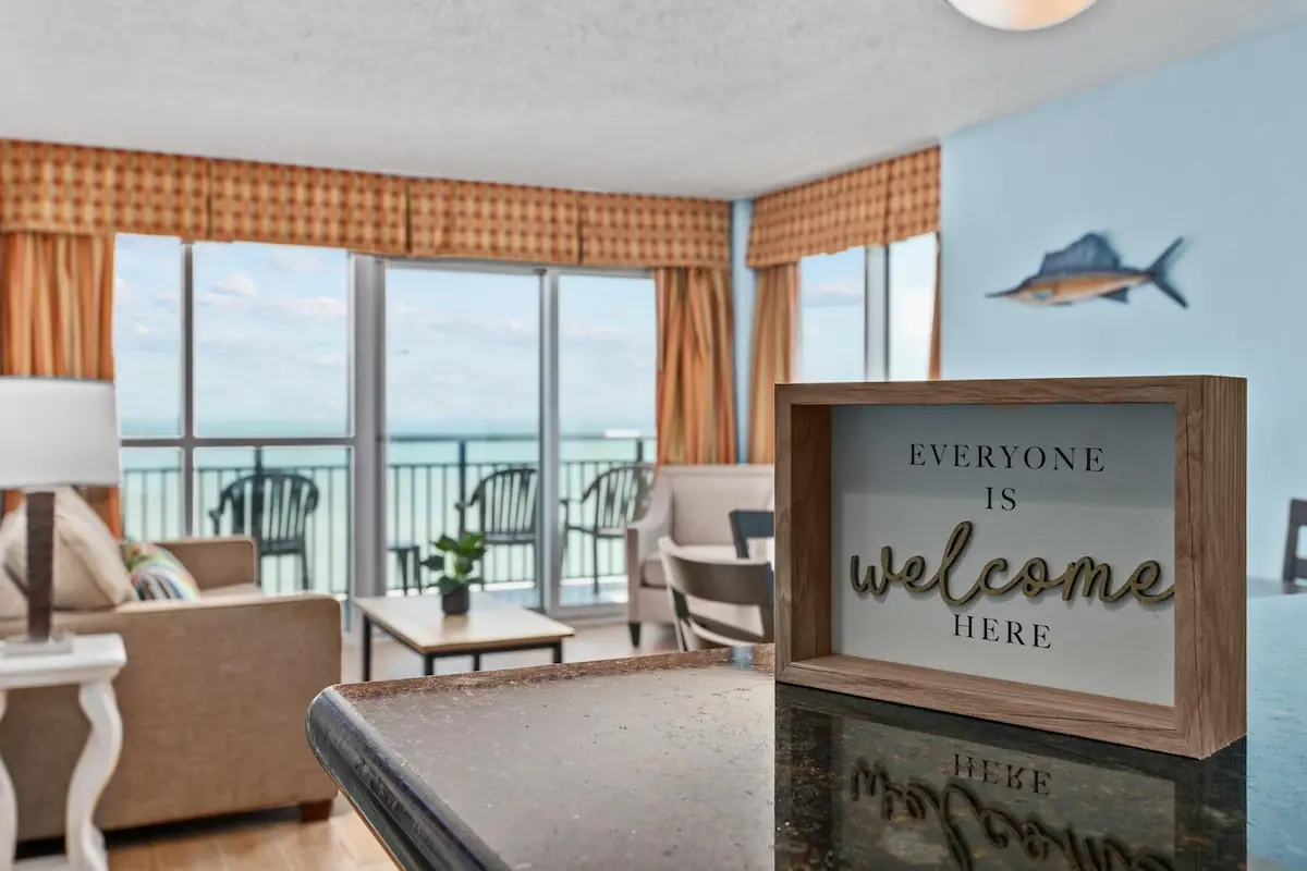 Living room and ocean balcony with a welcome sign in the foreground