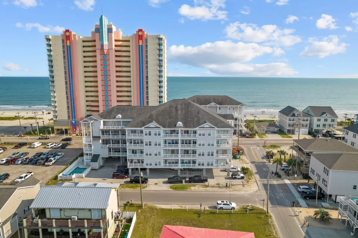 Aerial view of coastal buildings, a beachfront tower, and the ocean