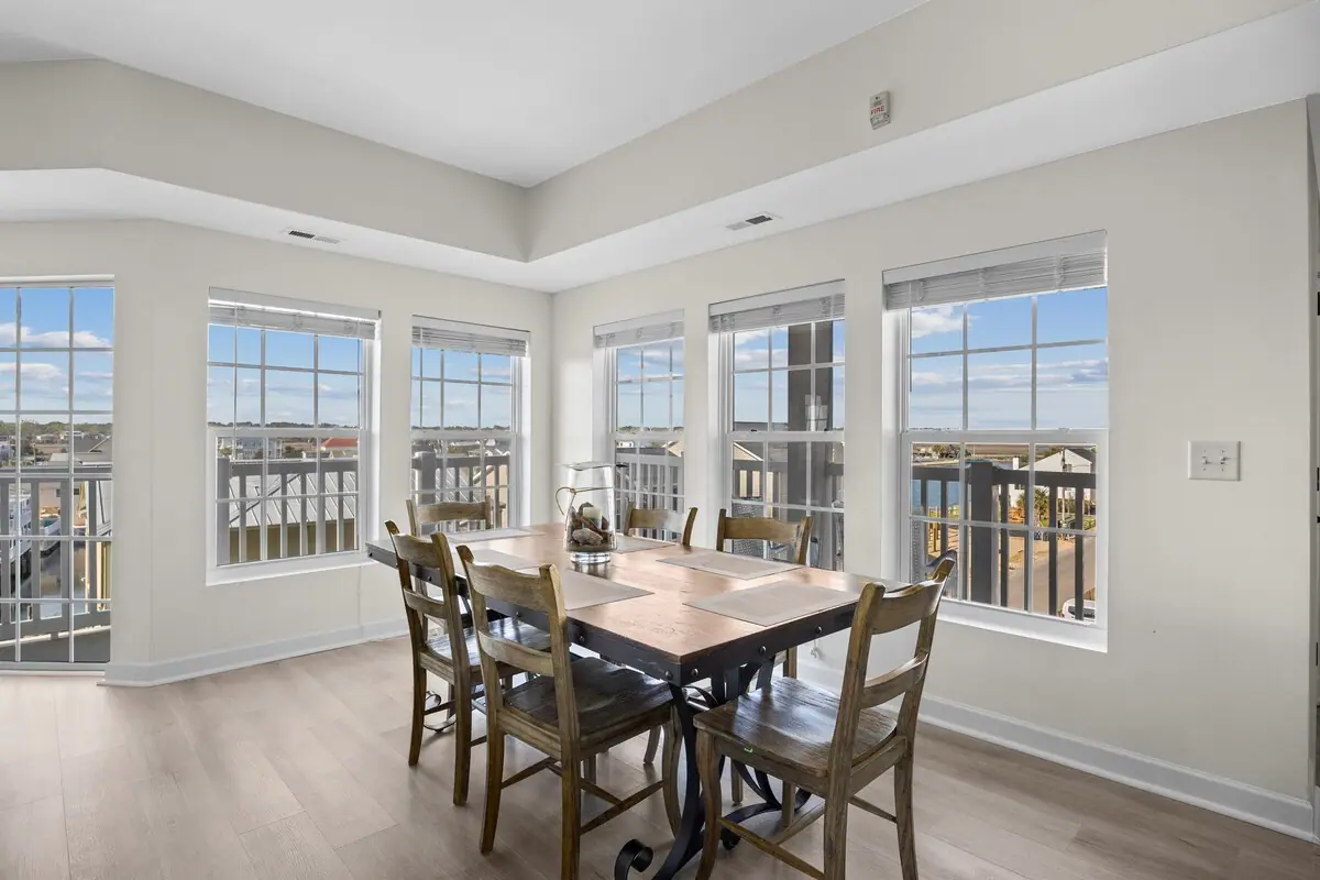 Dining table beside large windows overlooking neighboring buildings