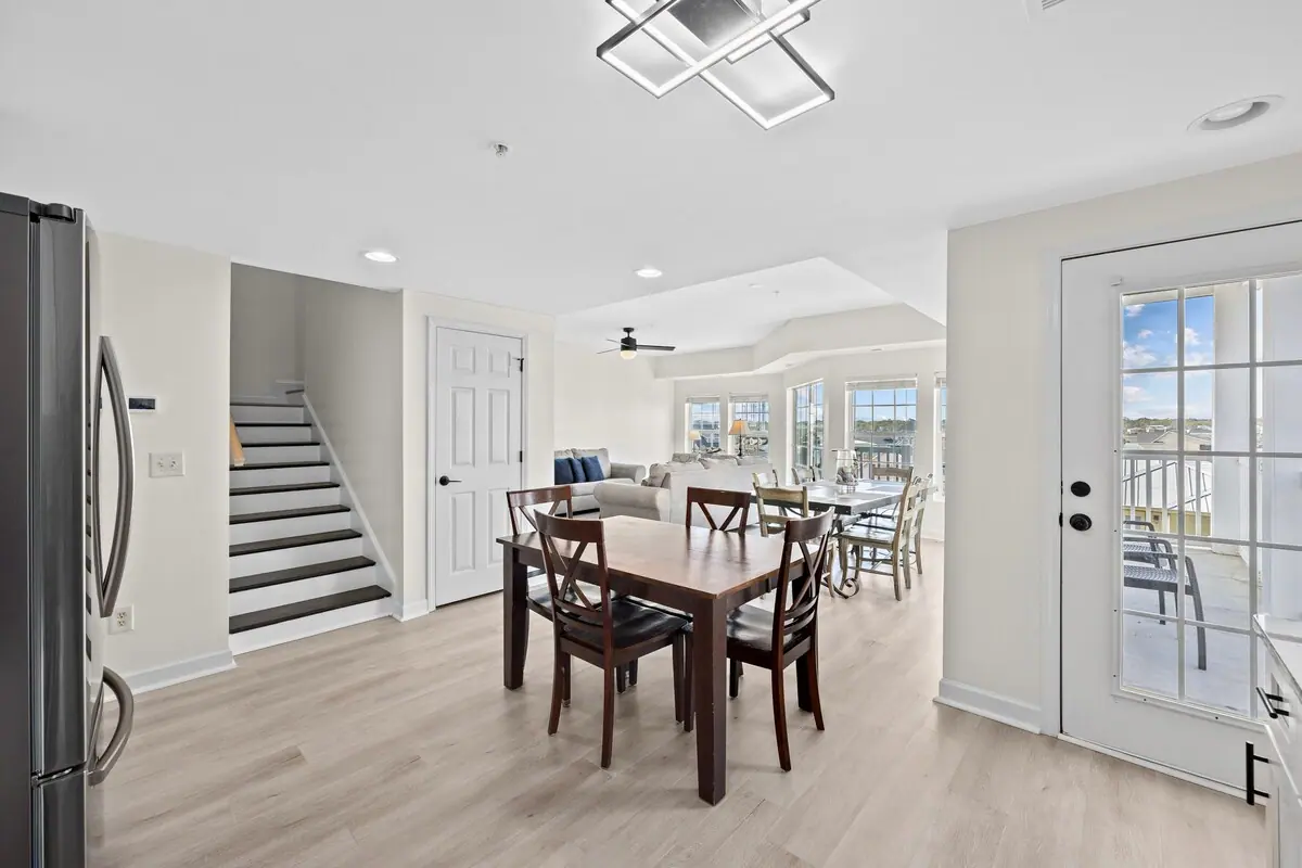 Open dining area with a staircase, living room, and balcony doors