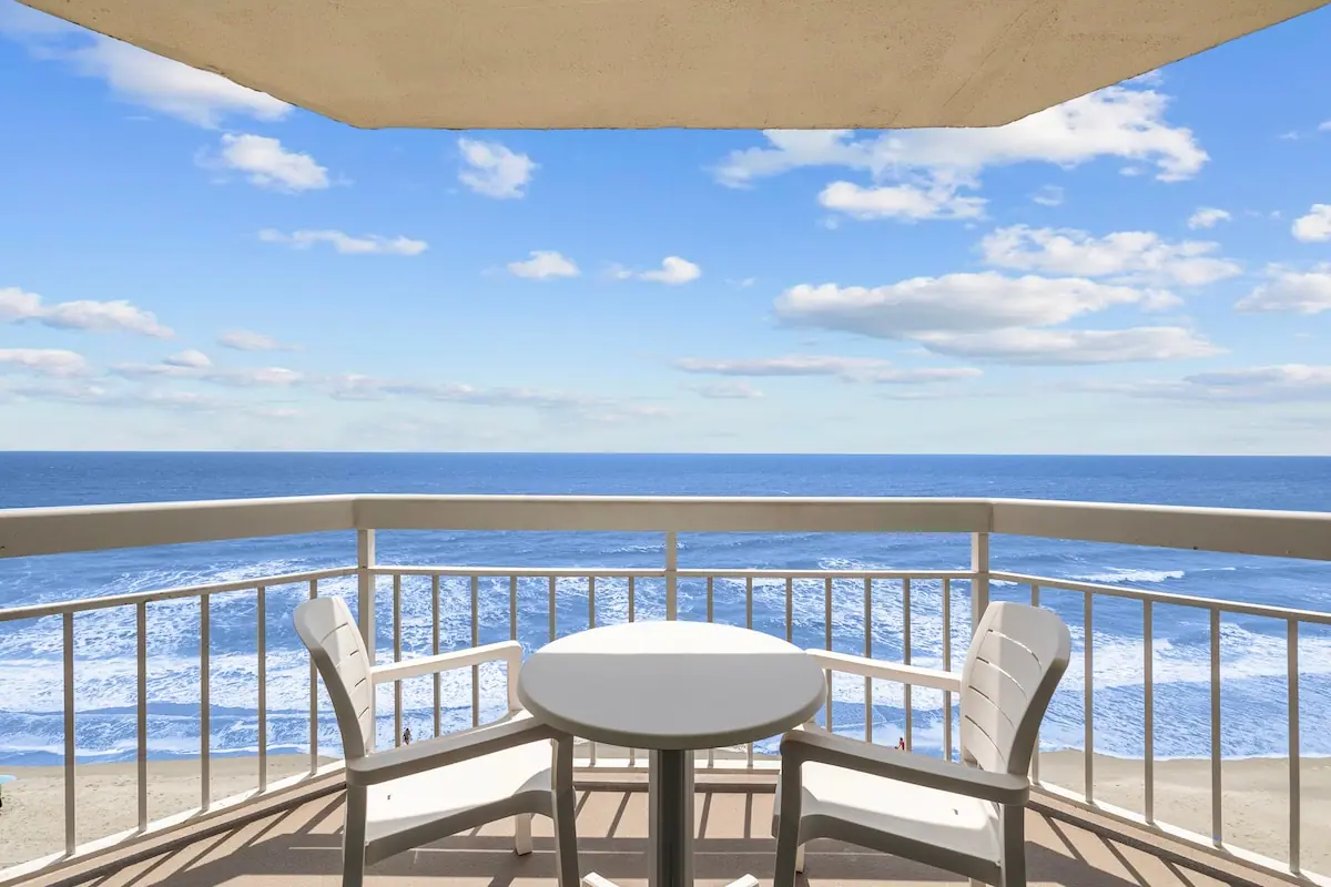 Balcony with two chairs and a round table overlooking the ocean