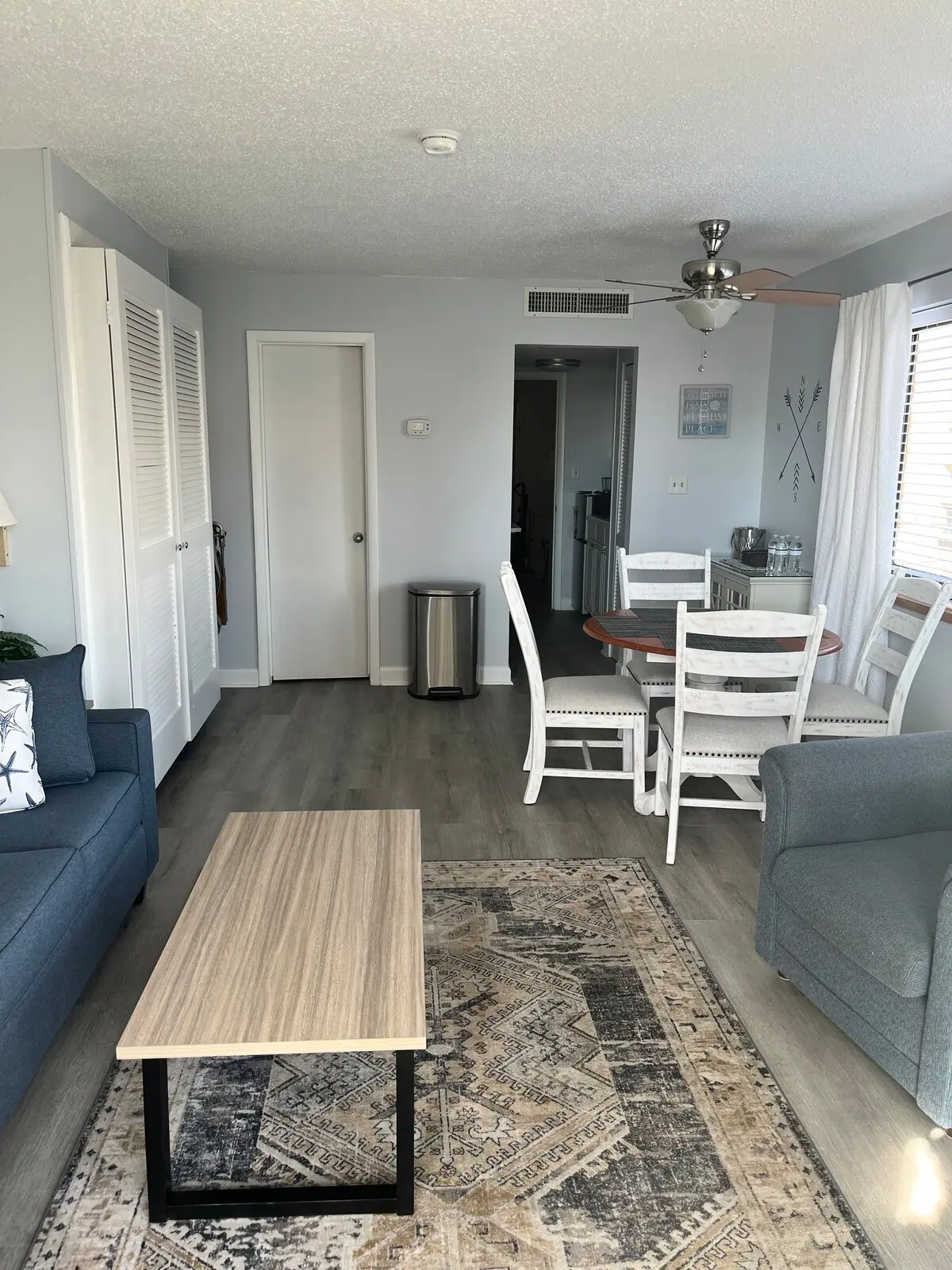 Narrow living area with sofa, dining table, and kitchenette doorway