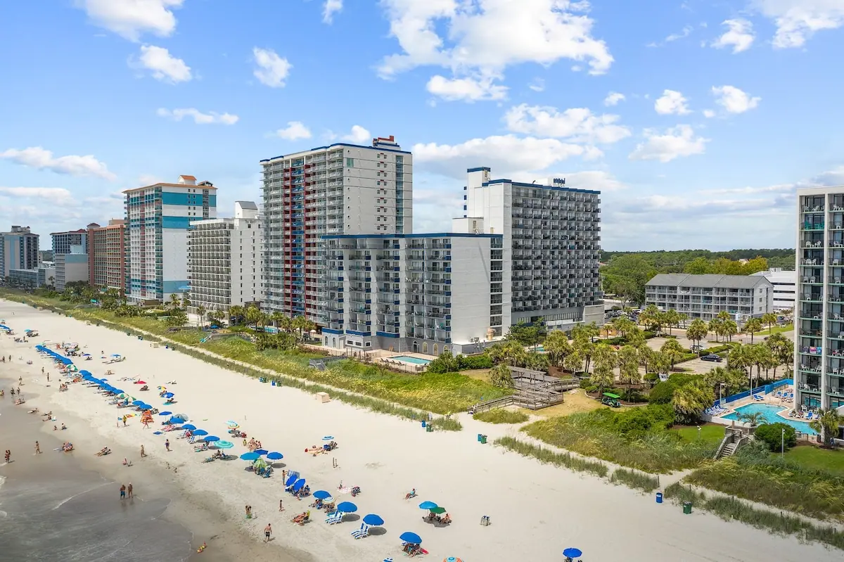 Aerial view of the sandy beach and a row of beachfront high-rise buildings
