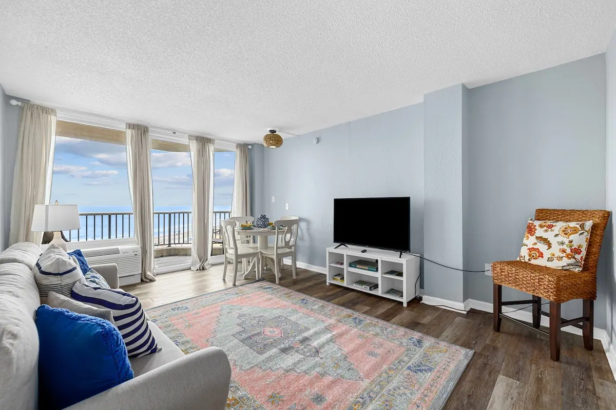 Living area with a blue chair and glass doors facing the ocean