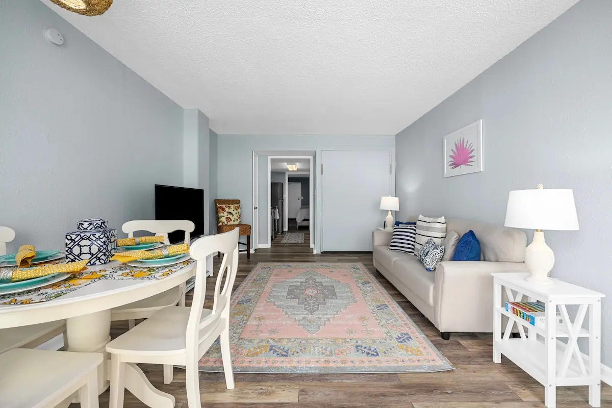 Dining table and pale sofa in a long living room