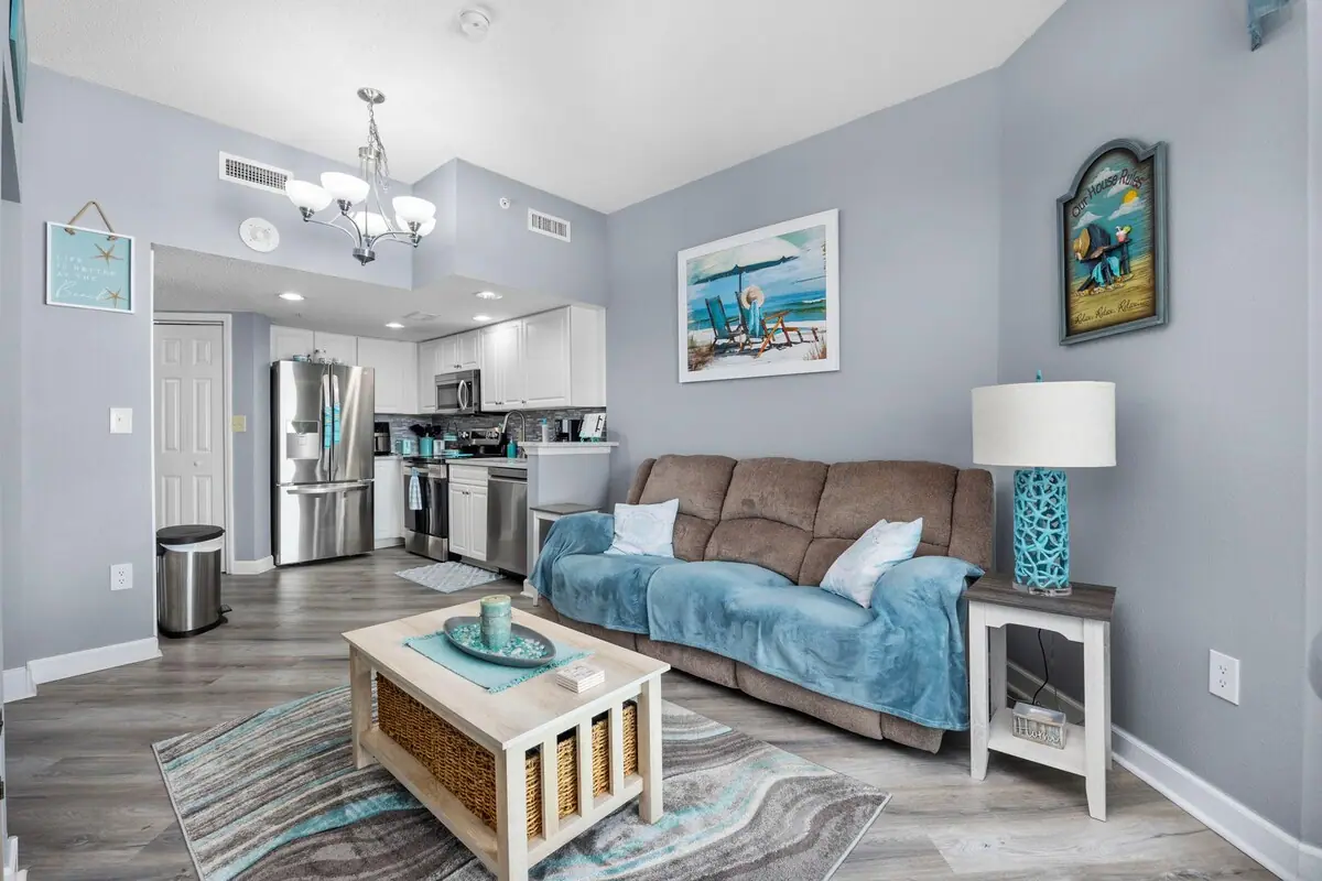 Gray sofa with blue throw beside the open kitchen