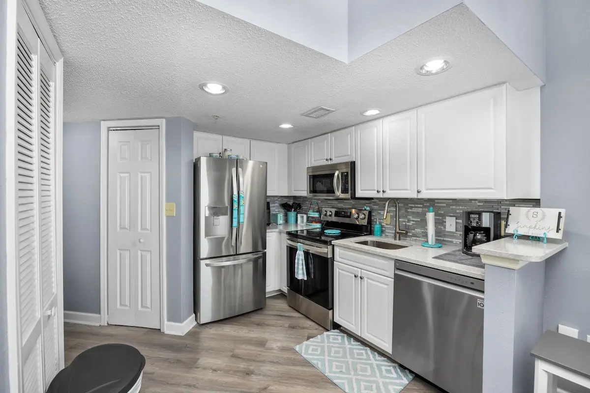 Compact kitchen with white cabinets and stainless appliances