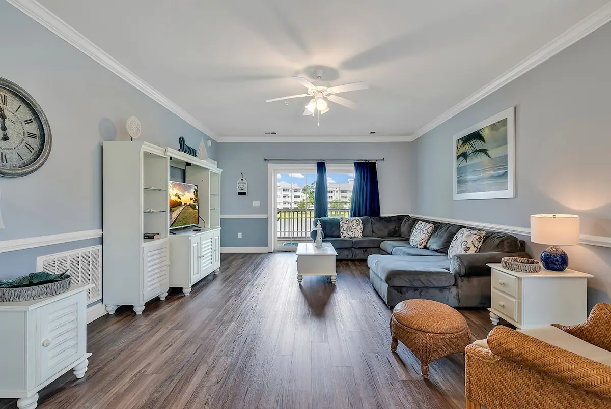 Gray sectional and white television cabinet beside sliding balcony doors
