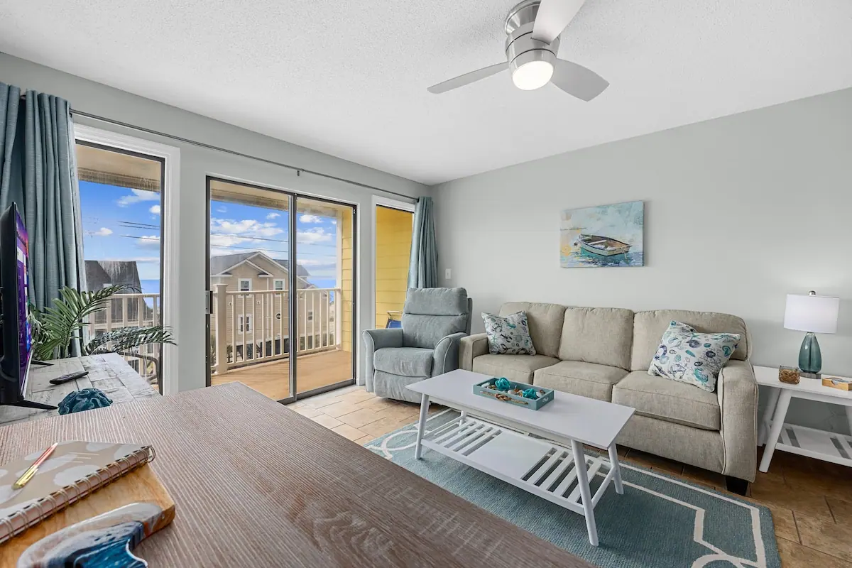 Living room with a gray sofa and sliding doors to a balcony