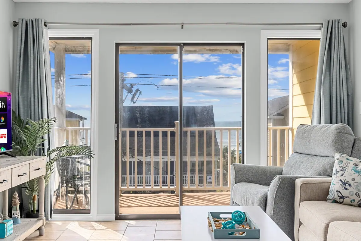 Glass balcony doors from the living area with water visible in the distance