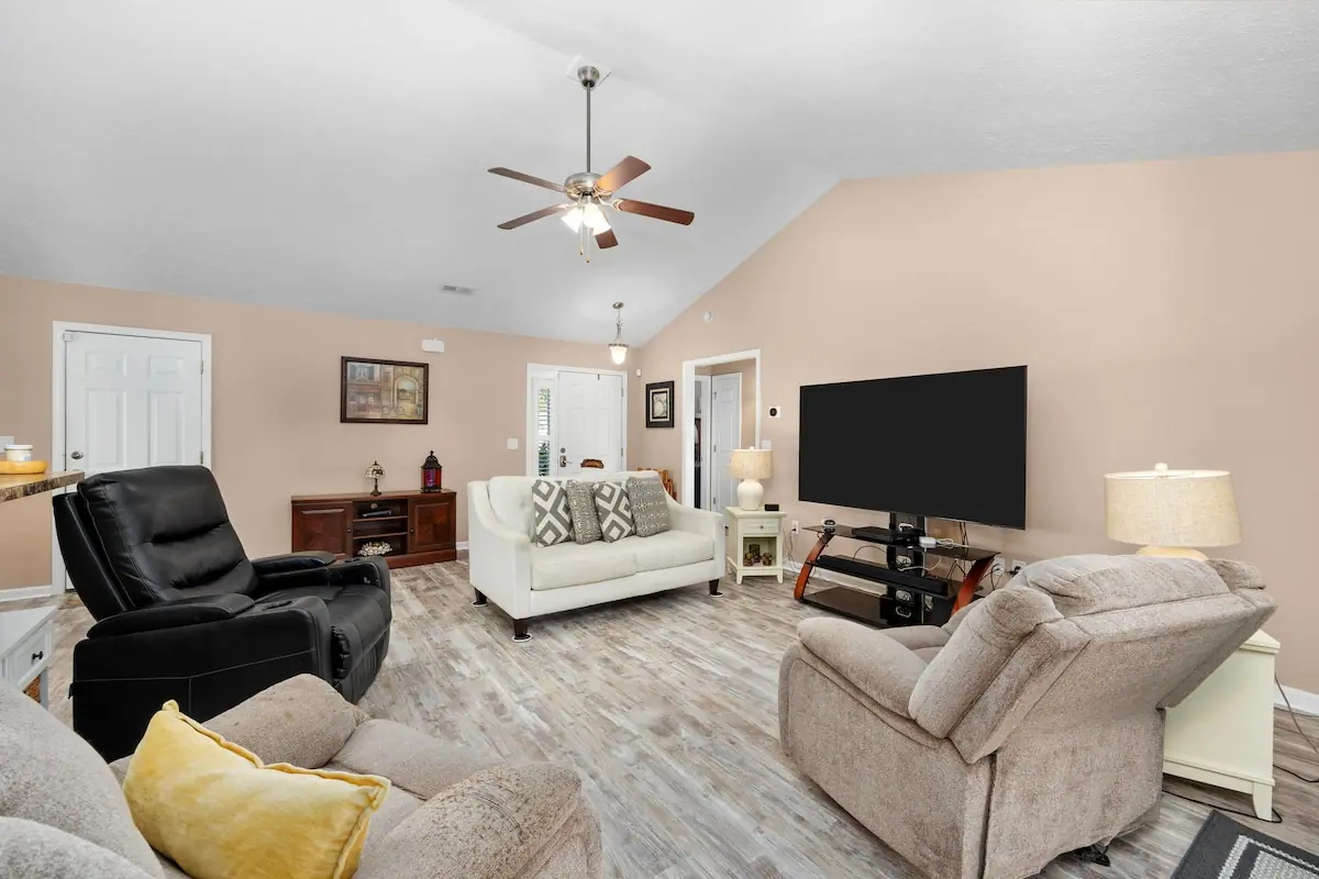 Living room with sofas, armchairs, and a wall-mounted television