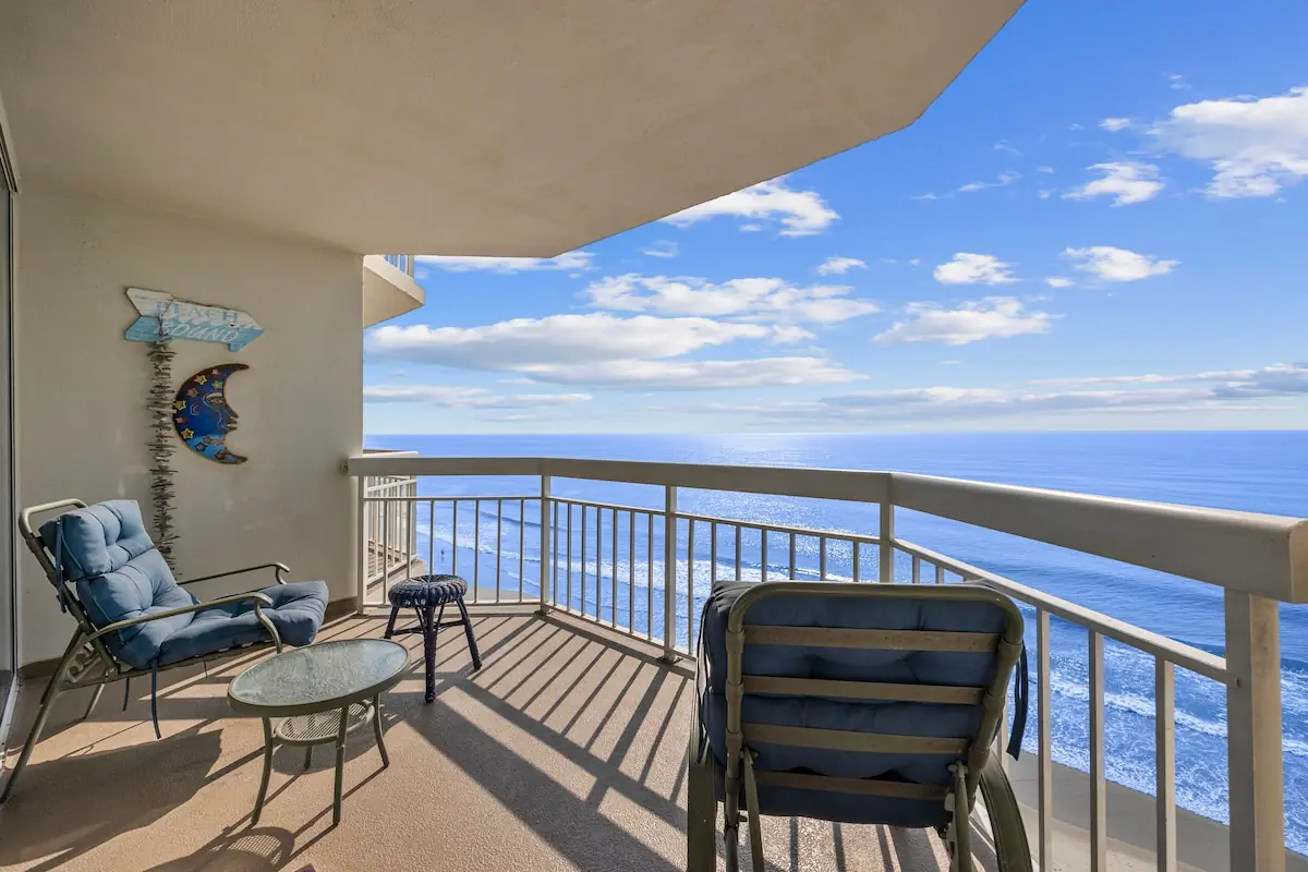 Balcony chairs overlooking the ocean and sandy shoreline