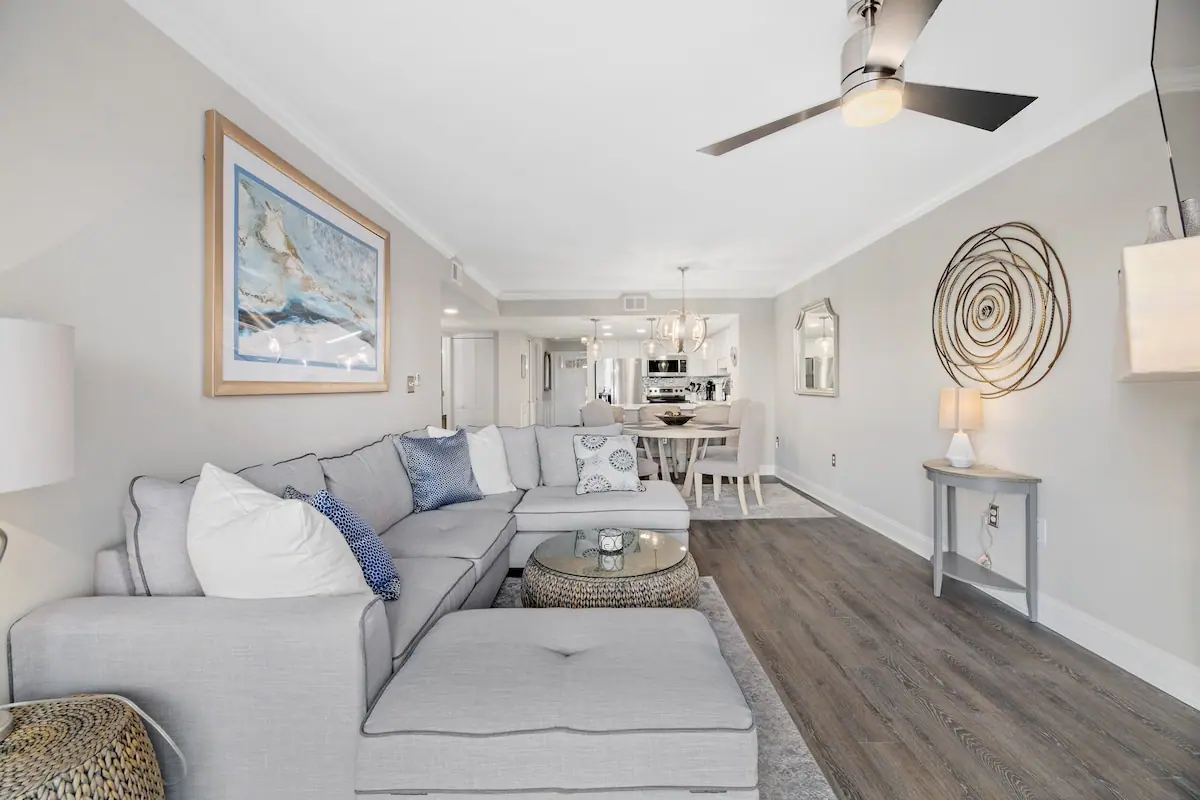 Living room with gray sectional and dining area farther back