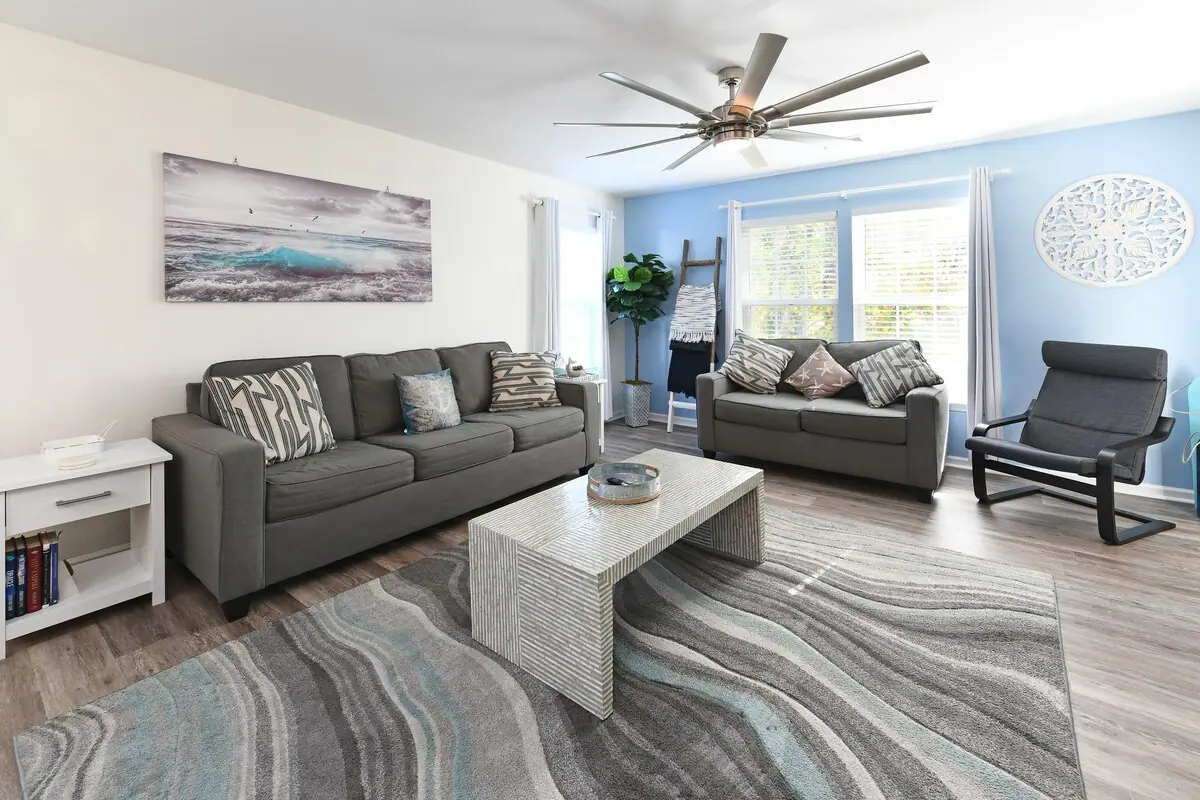 Living room with gray sofas, white coffee table, and blue accent wall