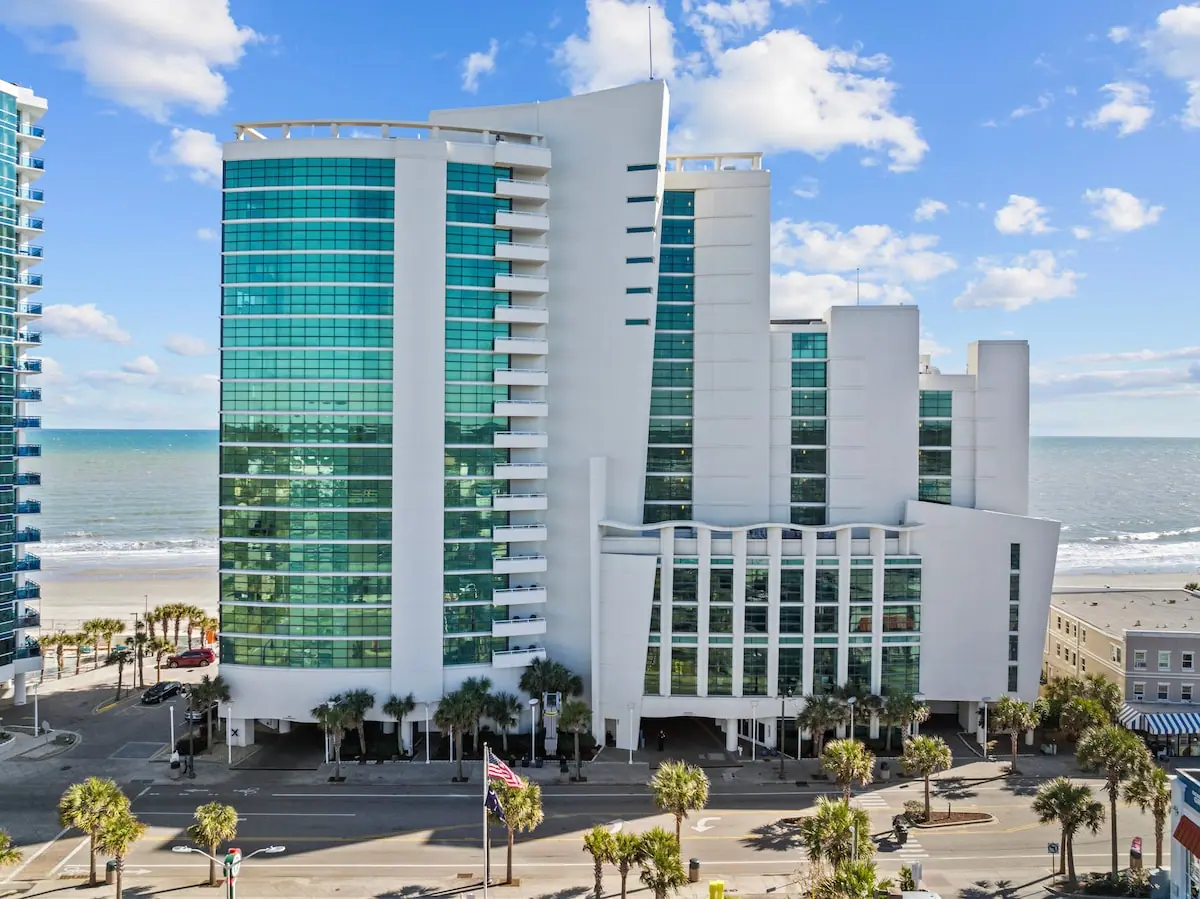 Curved glass high-rise building beside the beach and ocean
