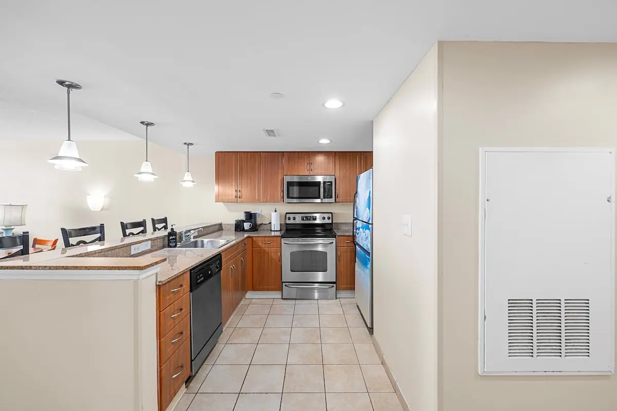 Kitchen with wood cabinets and stainless range viewed from the hall