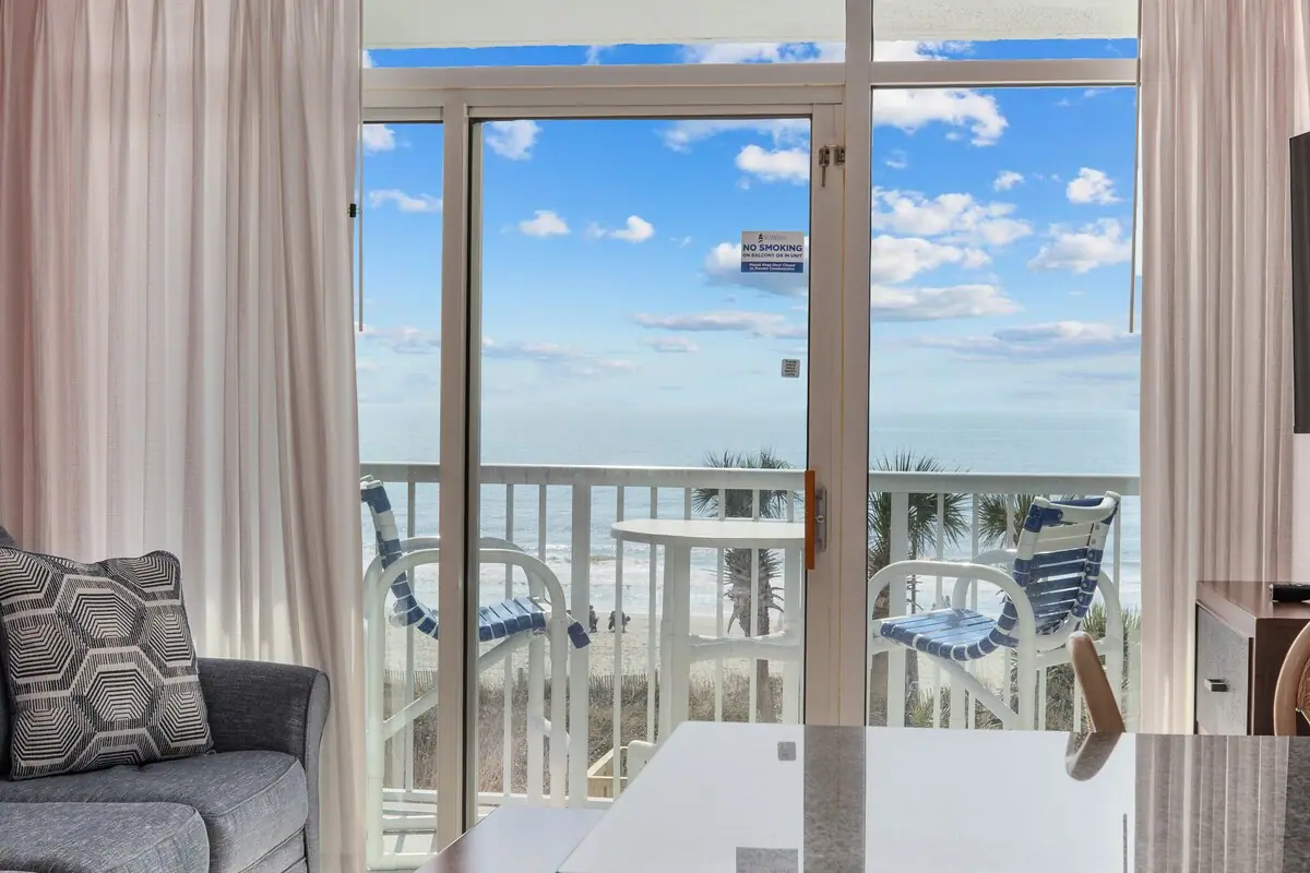 Balcony with two chairs and a small table overlooking the ocean