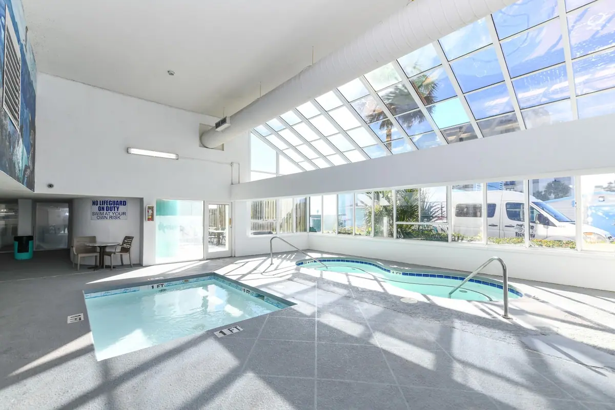 Bright indoor pool beneath a sloped glass roof