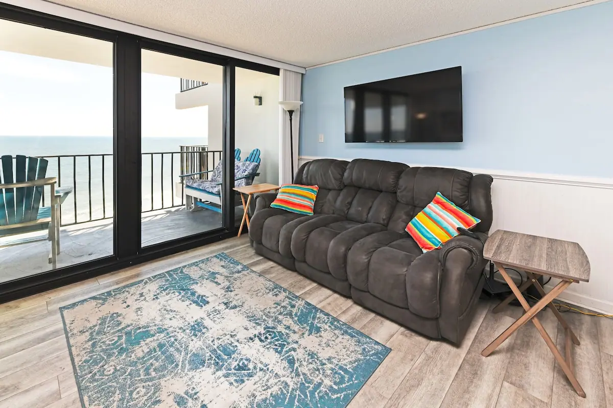 Dark sofa and balcony chairs overlooking the ocean