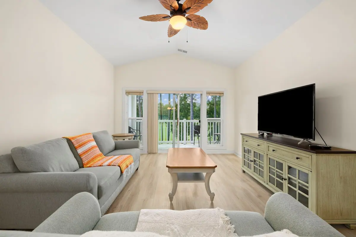 White living room with gray sofas and glass patio doors