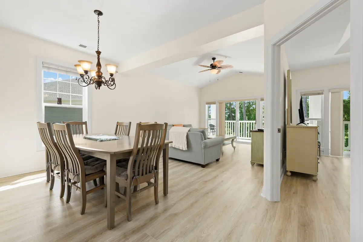 Dining table next to living room and kitchen