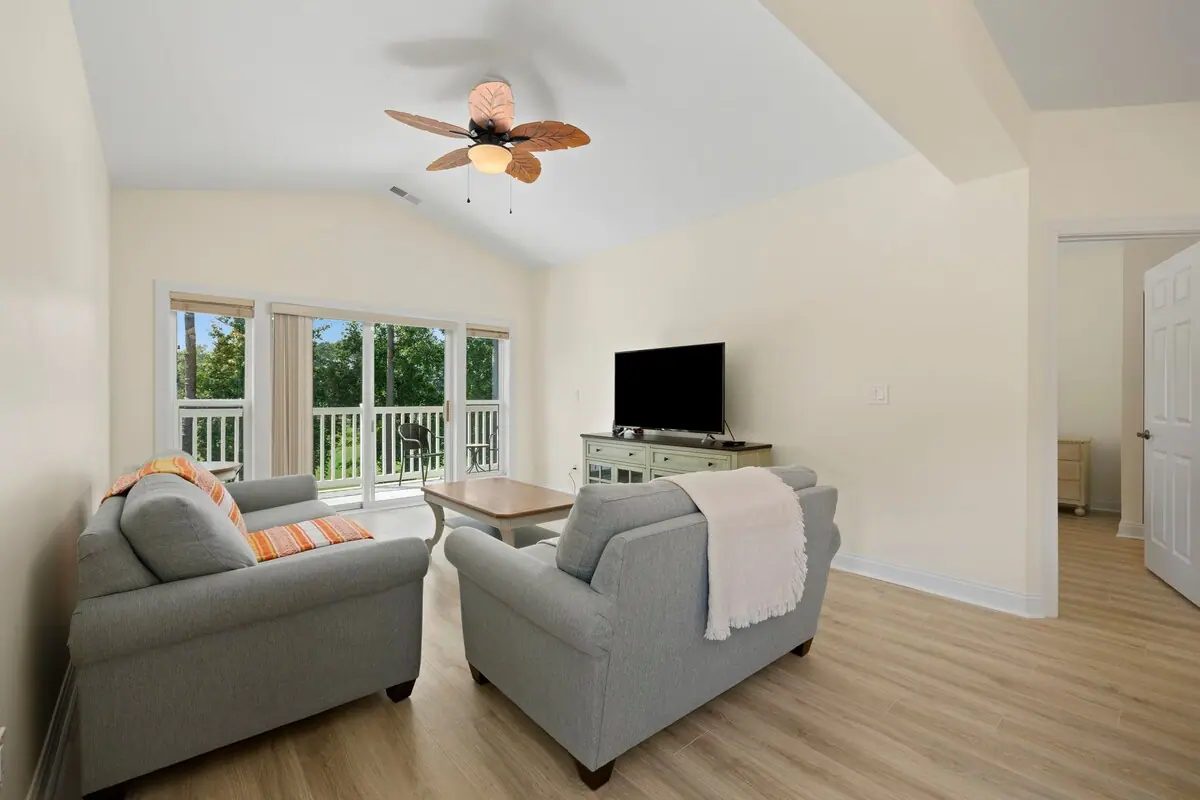 Gray sofas around wooden coffee table beside patio doors