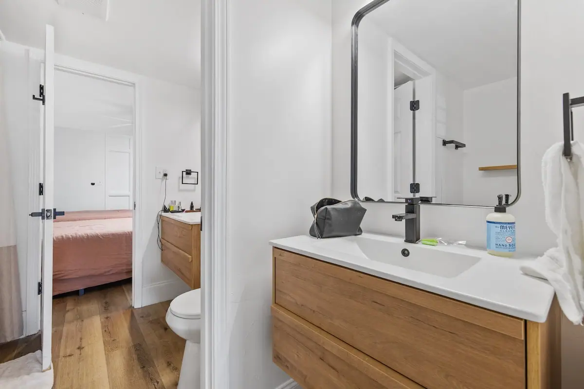 Bathroom with wooden vanity, white sink, and glass shower enclosure