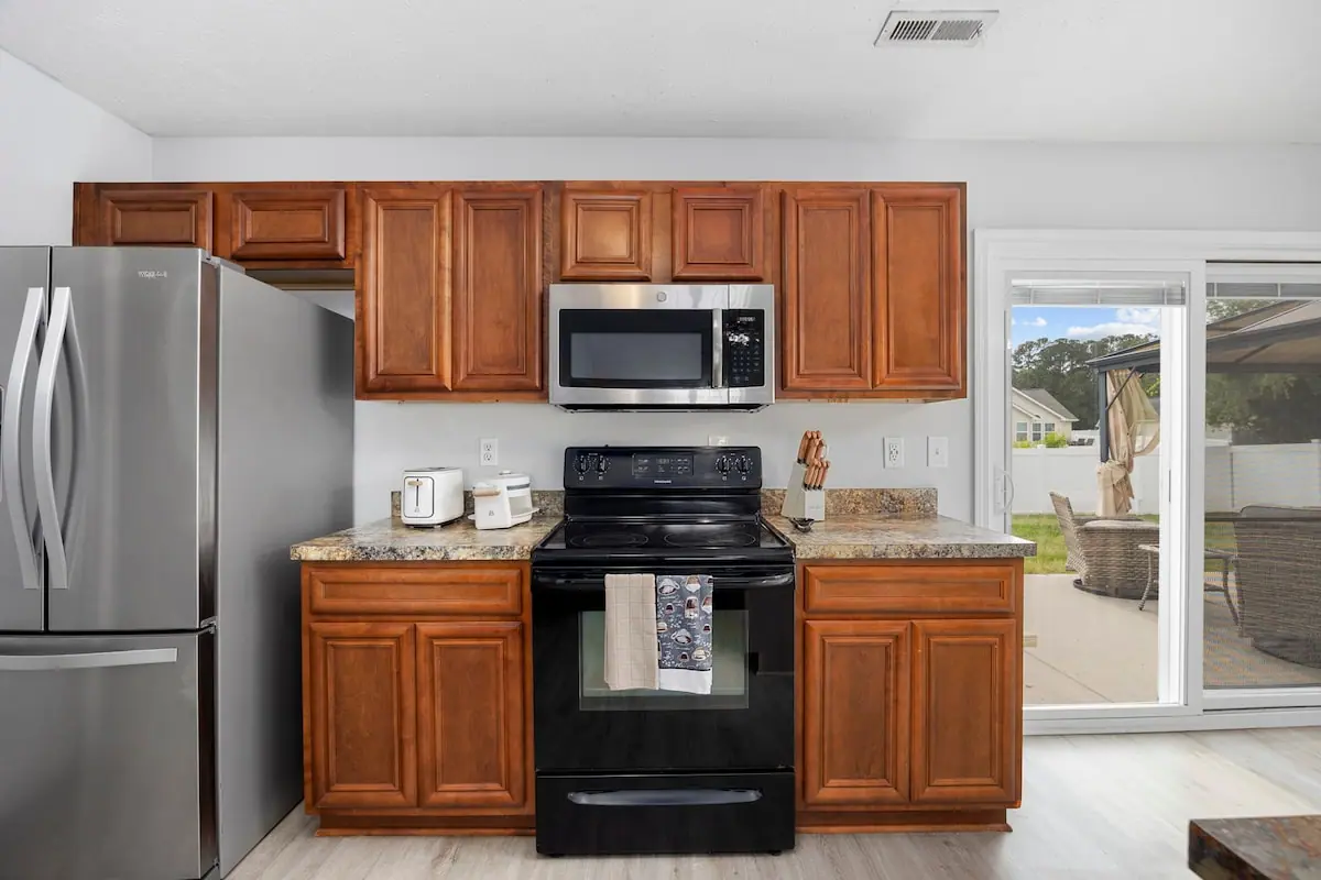 Kitchen with wood cabinets and glass door to patio seating