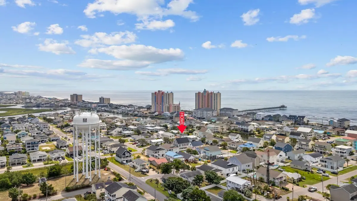 Aerial view of a coastal neighborhood, water tower, and ocean