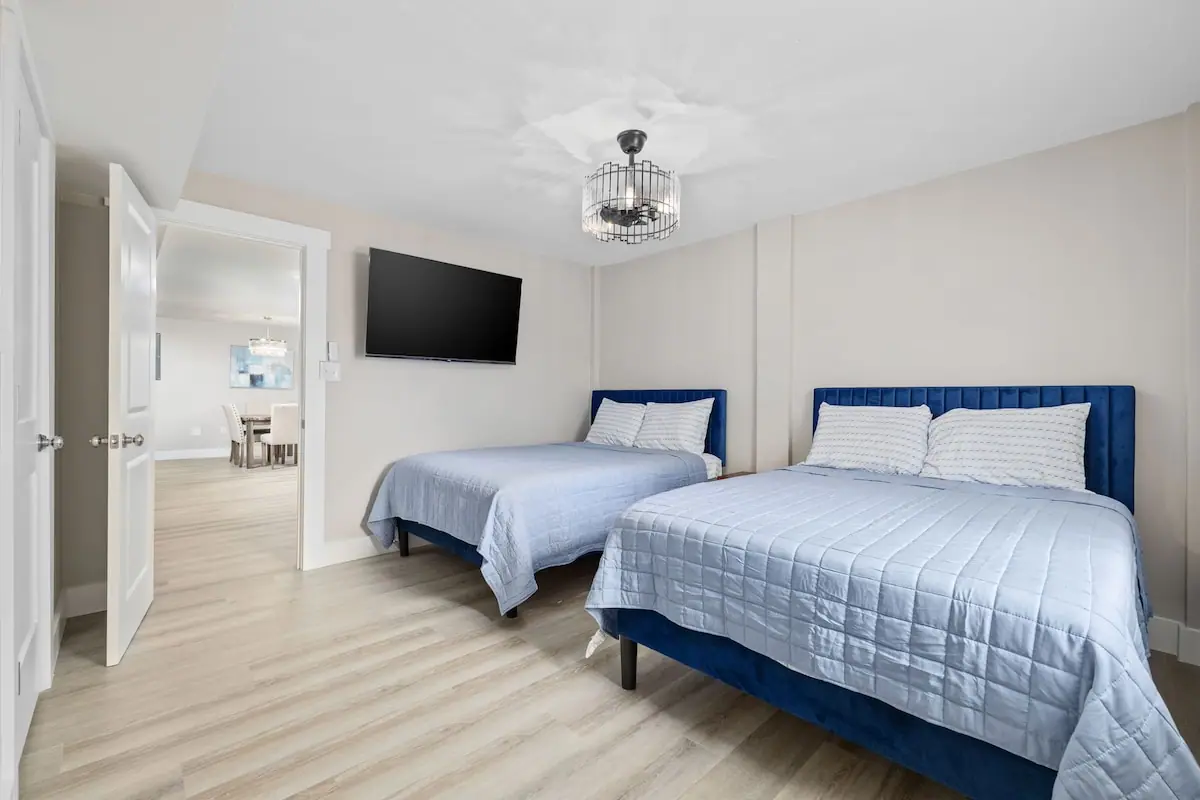 Bedroom with two blue-framed beds and wall-mounted television