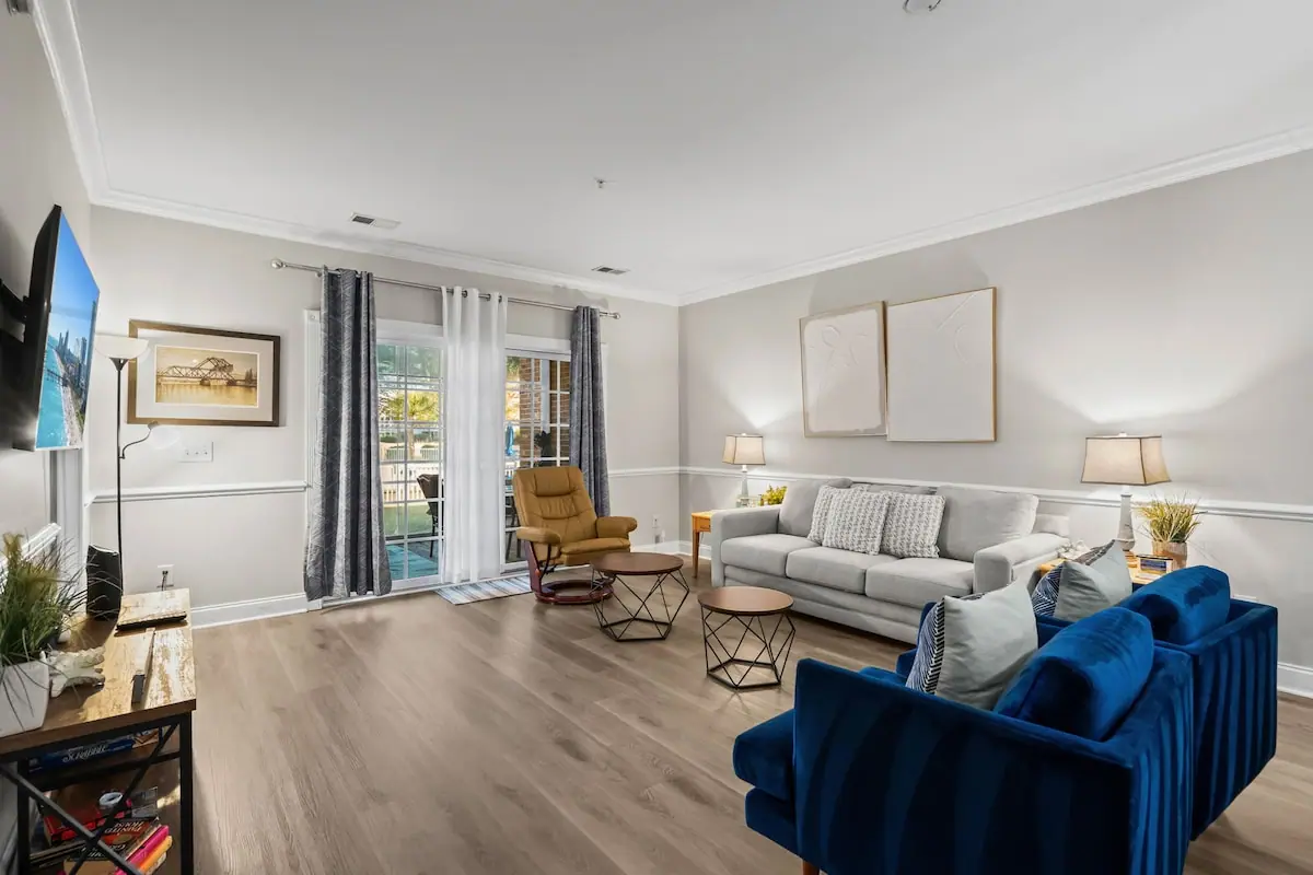 Living room with gray and blue sofas beside sliding balcony doors
