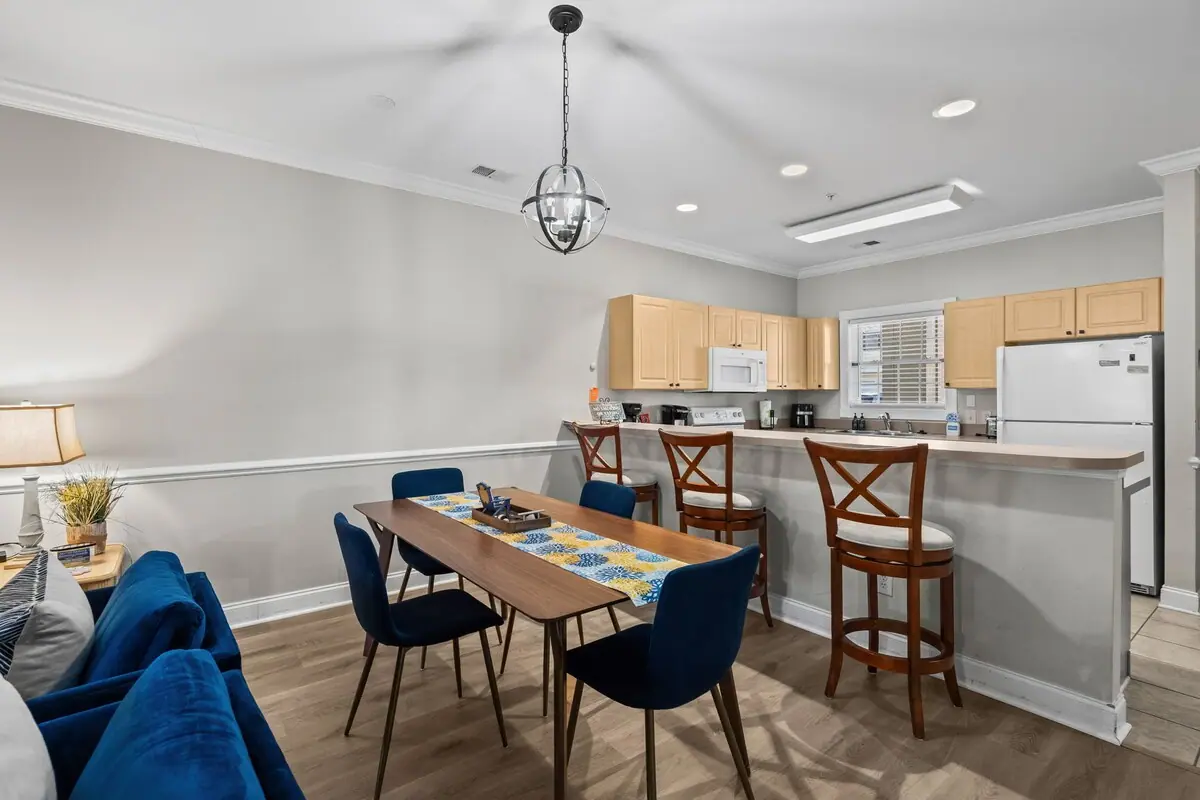 Dining table with blue upholstered chairs beside white kitchen counter