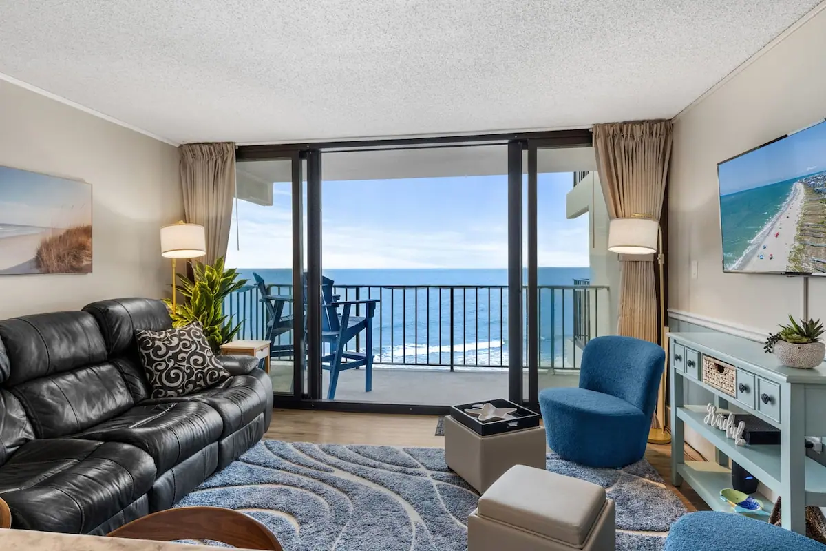 Living room with leather seating and glass doors to an ocean balcony