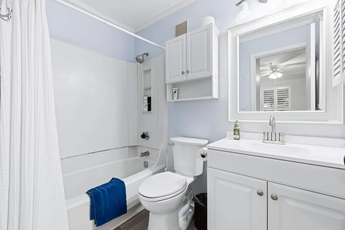 Bathroom with a white vanity, mirror, and shower over the bathtub
